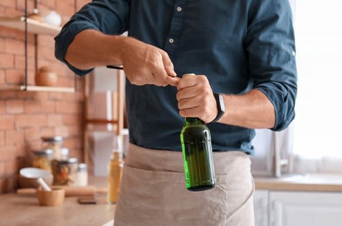 Man opens bottle with opener