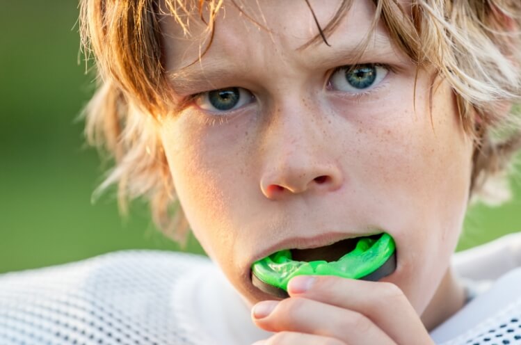 Teen placing athletic mouthguards