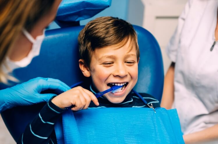 Child smiling at dental office after pulp therapy