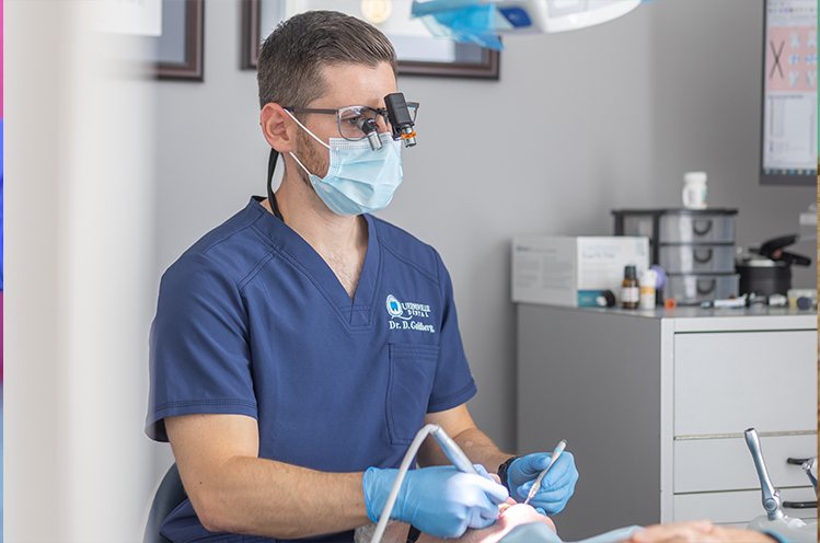 Dentist comparing dental patient's smile to metal free dental restoration color options