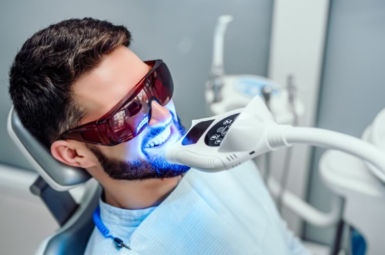 Man receiving professional teeth whitening treatment
