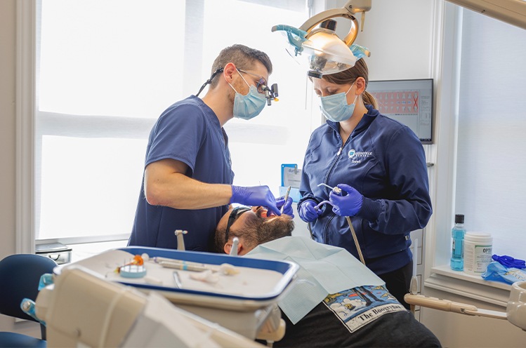 Woman holding cheek in pain before emergency dentistry