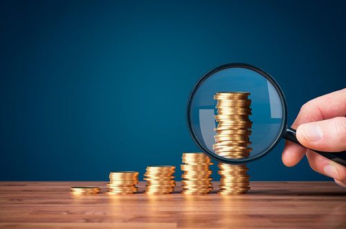 Stacks of coins examined with magnifying glass