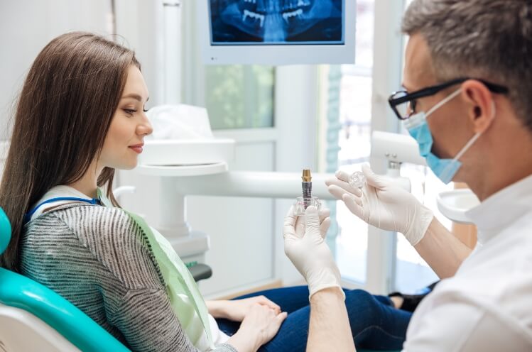 Dentist explaining the four step dental implant process