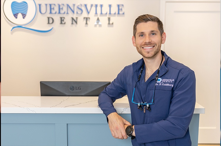 Woman looking at smile after tooth replacement with dental implants