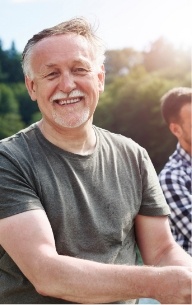 Man sharing full smile after tooth replacement with dental implants