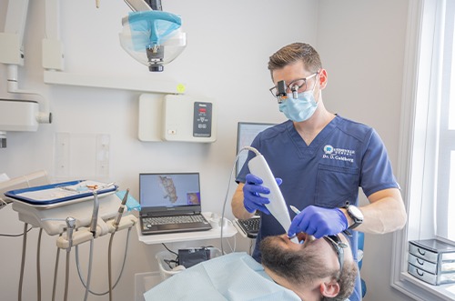 Closeup of patient placing clear aligners in their mouth 