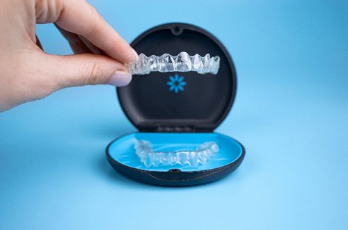 Closeup of patient placing Invisalign aligners in case
