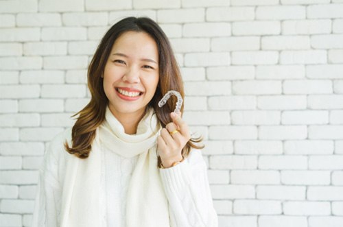 Woman holding an Invisalign aligner