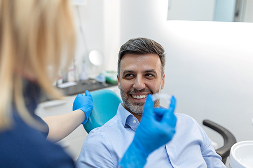 a dentist showing a patient their Invisalign aligners