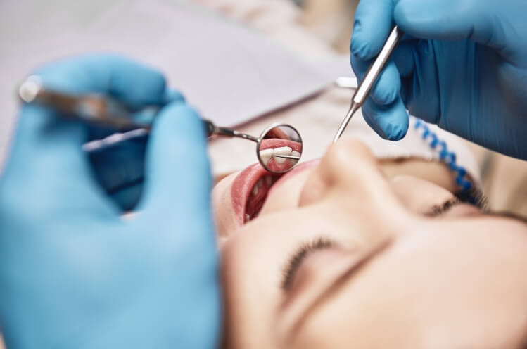 Dentist conducting an oral cancer screening