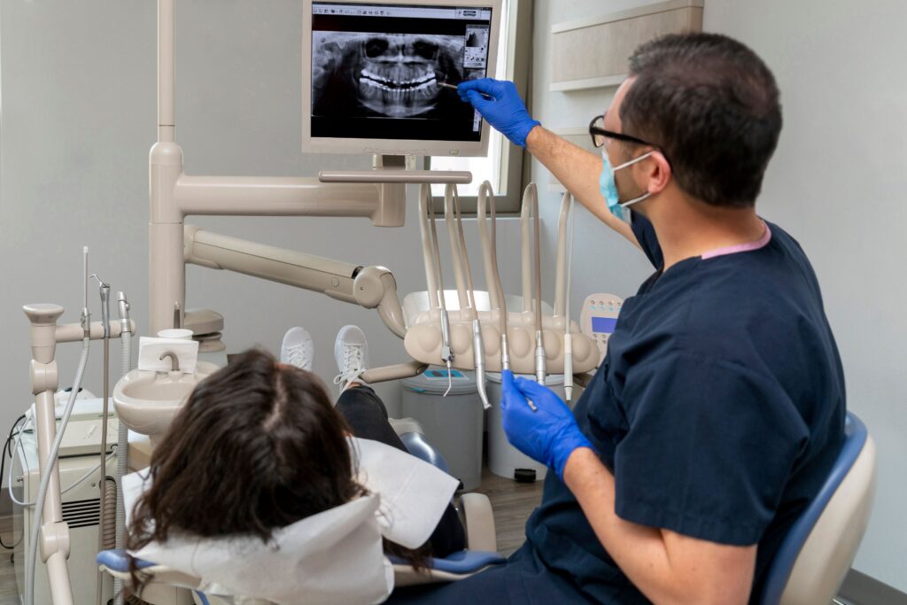 Dentist showing X-rays to patient in dental chair