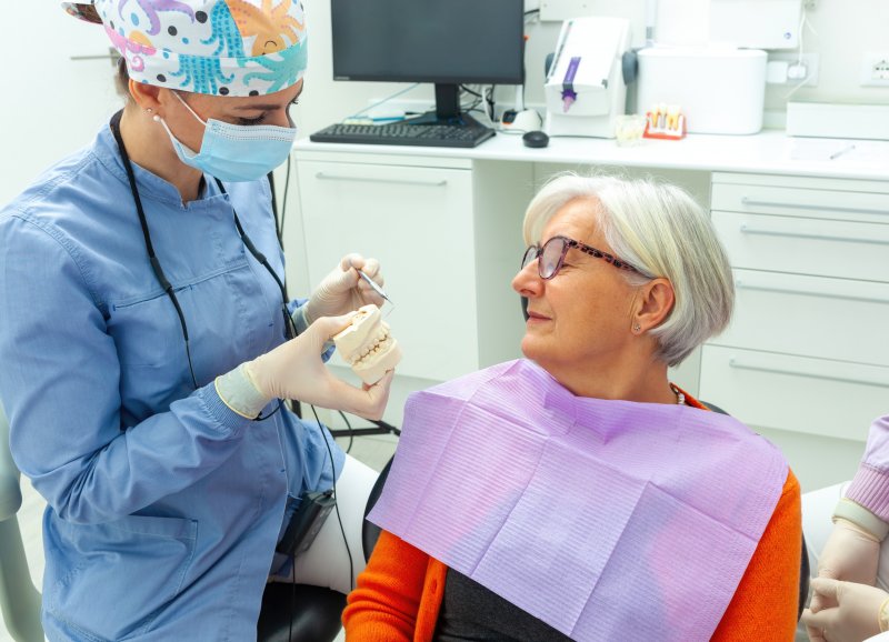 older woman listening to dentist discuss dental implants