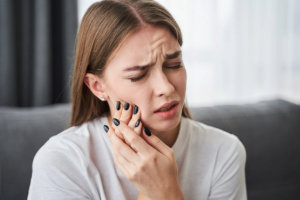 Woman sitting on couch with toothache